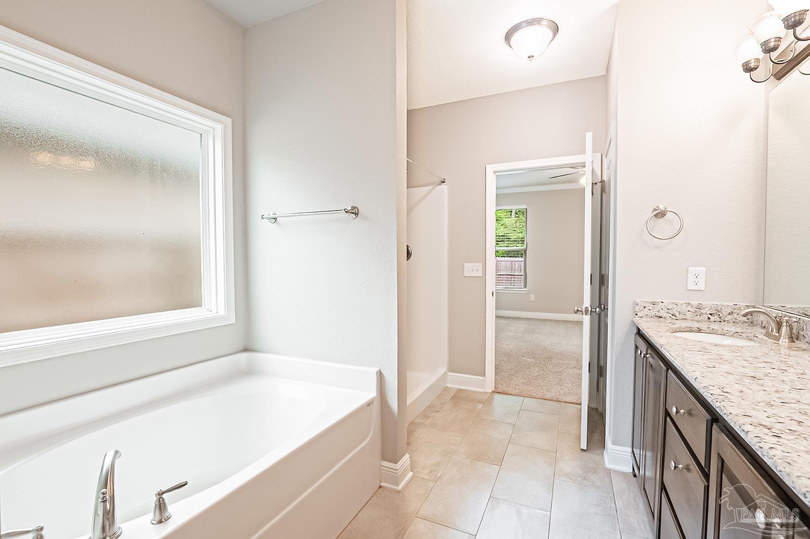 5398 Parkside Drive Pace, FL 32571 - Photo 34 of 36 a bathroom with a granite countertop tub a sink and a mirror