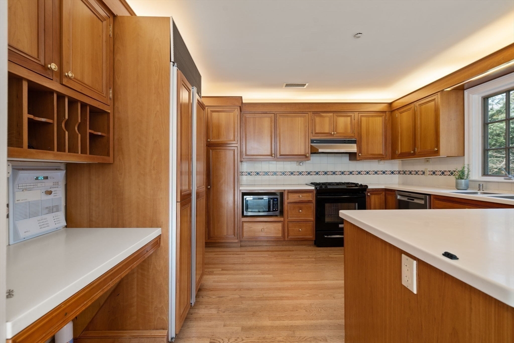 530 Clinton Road Brookline, MA 02467 - Photo 11 of 25 a kitchen with stainless steel appliances granite countertop a sink and cabinets