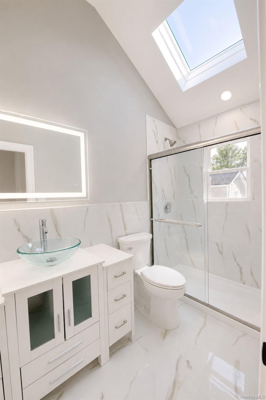 1316 R Street Elmont, NY 11003 - Photo 19 of 24 a bathroom with a sink toilet and shower