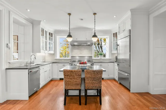 a kitchen with stainless steel appliances granite countertop a stove and refrigerator a sink with wooden floor