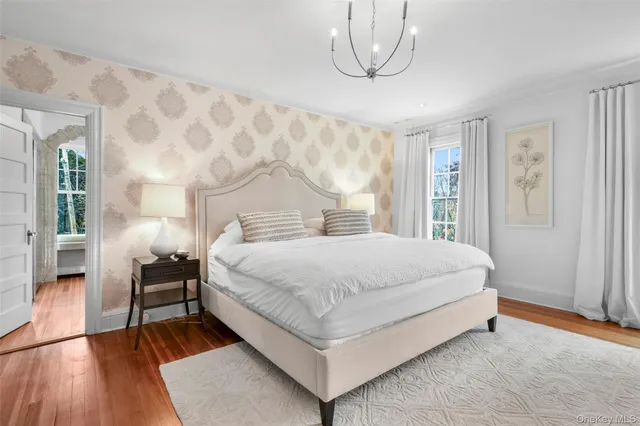 a spacious bedroom with a bed and a flat screen tv