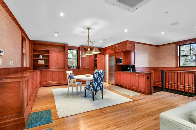 a dining room with stainless steel appliances kitchen island granite countertop a table chairs and a refrigerator