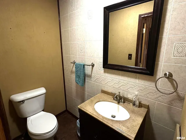 a bathroom with a granite countertop toilet sink and mirror