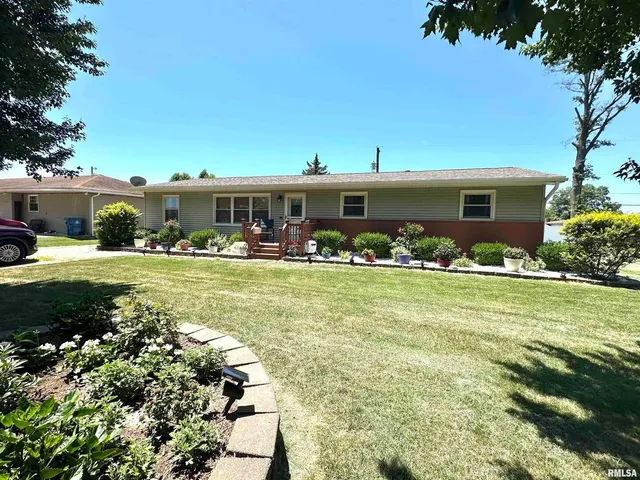 a front view of house with garden and trees