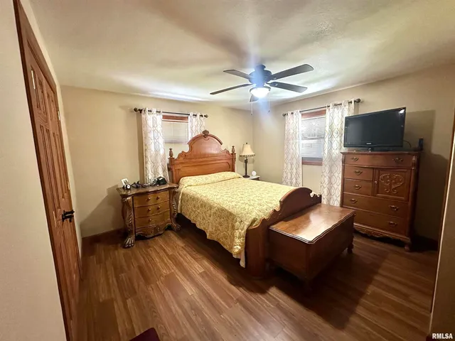 a bedroom with a bed and a flat tv screen on dresser