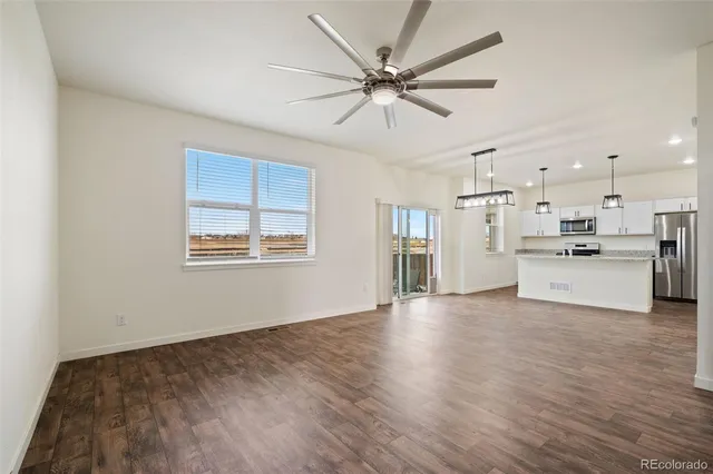 a view of a kitchen with wooden floor and a window