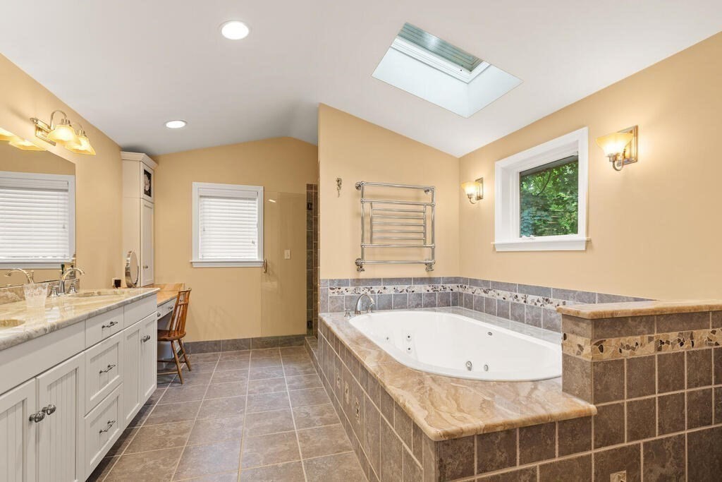 82 Cary Avenue Lexington, MA 02421 - Photo 21 of 29 a spacious bathroom with a granite countertop tub sink and mirror
