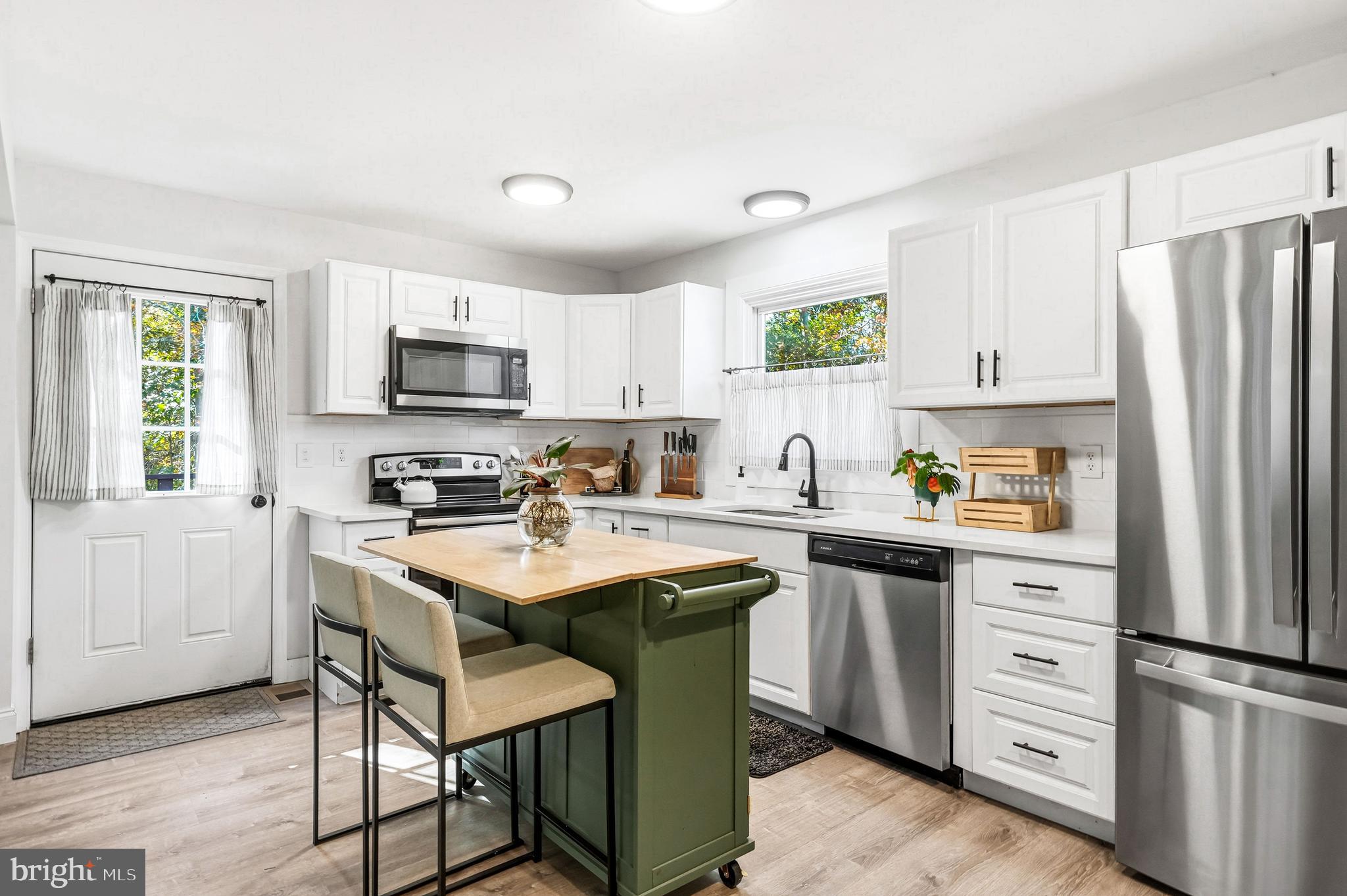 209 Myrtle Lane Berlin, NJ 08009 - Photo 11 of 36 a kitchen with a sink a stove a refrigerator and white cabinets with wooden floor