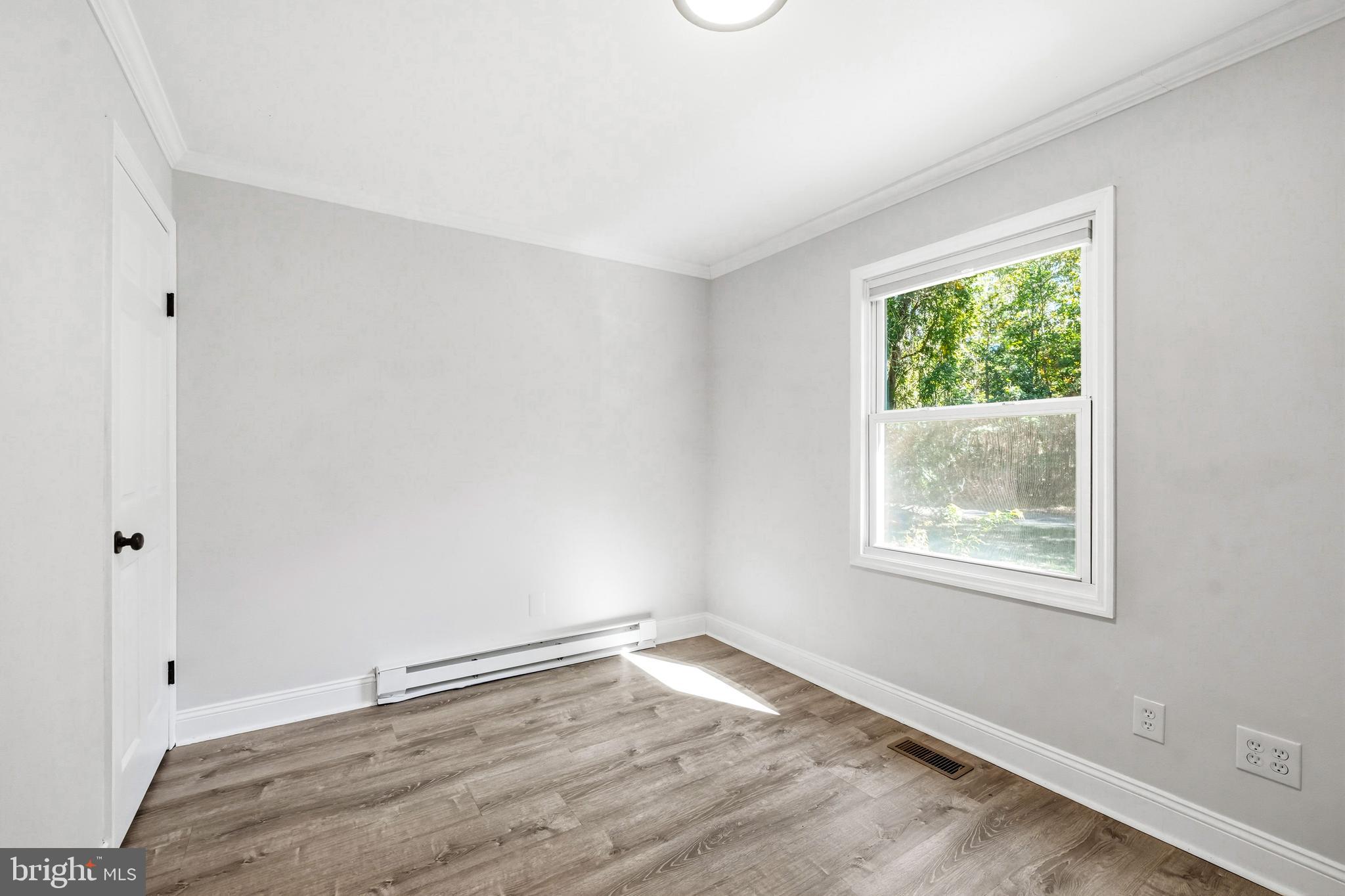 209 Myrtle Lane Berlin, NJ 08009 - Photo 15 of 36 a view of an empty room with wooden floor and a window