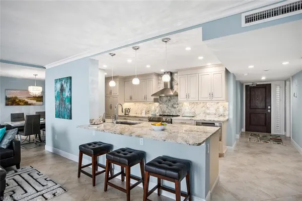 a large kitchen with kitchen island a dining table and chairs