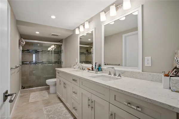 a spacious bathroom with a double vanity sink mirror and toilet
