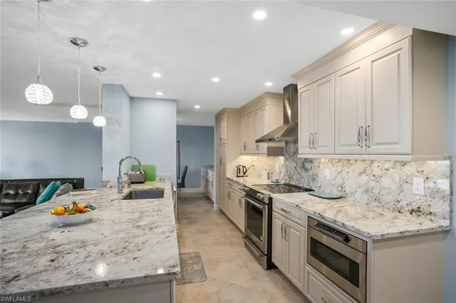 a kitchen with stainless steel appliances granite countertop a stove a sink and a refrigerator