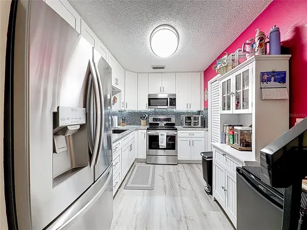 a kitchen with granite countertop a sink stove and refrigerator
