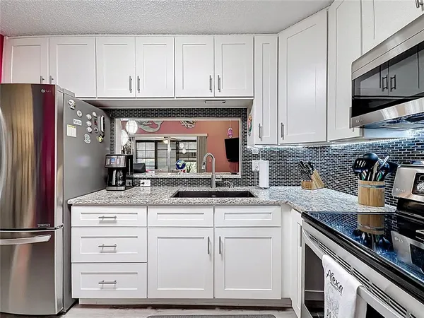 a kitchen with cabinets stainless steel appliances and sink