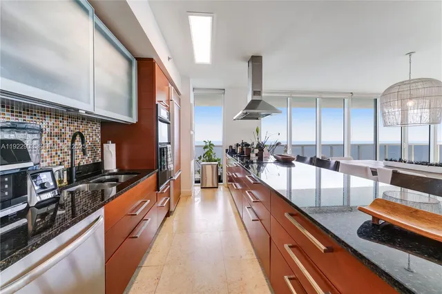 a view of a kitchen with stainless steel appliances granite countertop a sink and wooden floors