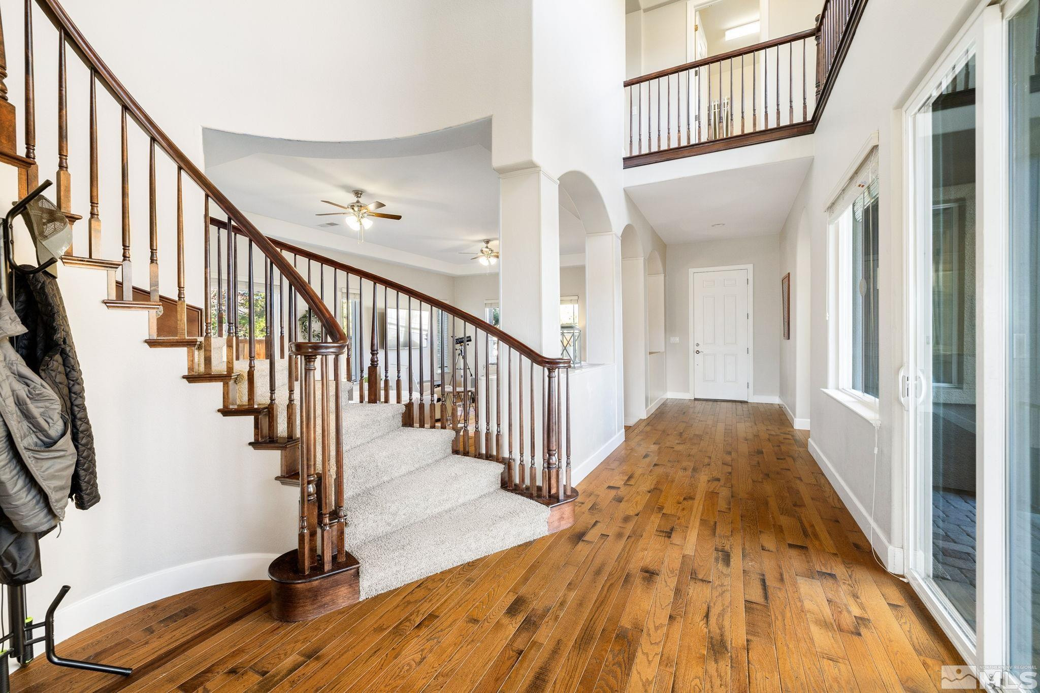 10135 Burghley Lane Reno, NV 89521 - Photo 11 of 39 a view of staircase with lots of frames on wall and wooden floor