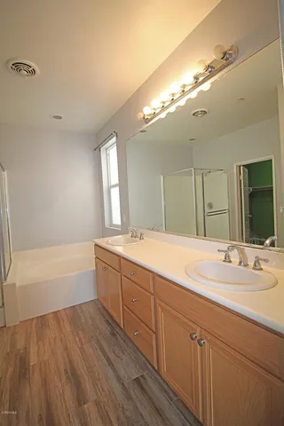 a spacious bathroom with a double vanity sink a mirror and a bathtub