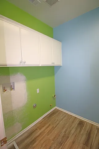 a view of a room with wooden floor and cabinets