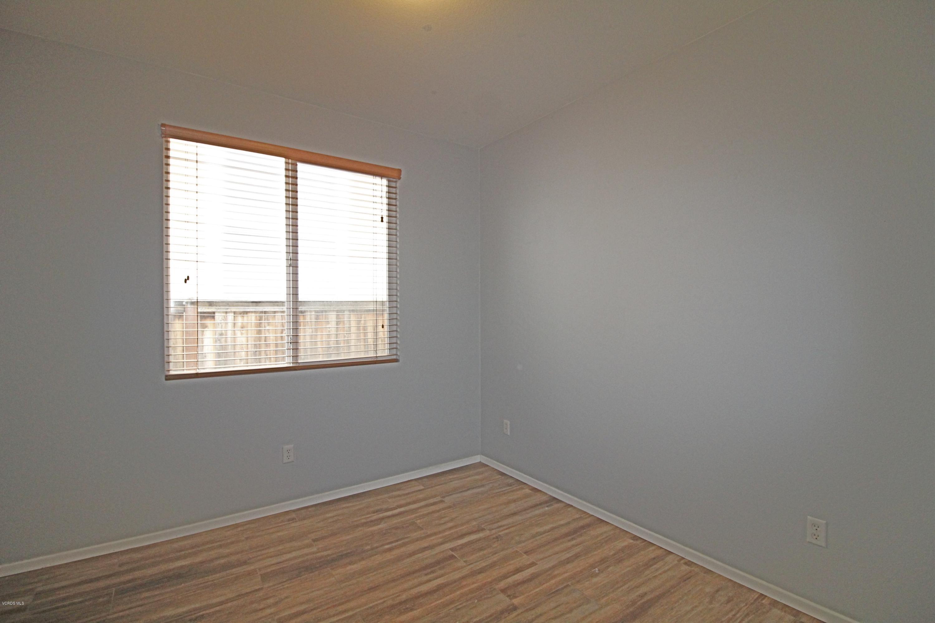 351 Huerta Street Oxnard, CA 93030 - Photo 10 of 18 a view of an empty room with wooden floor and a window