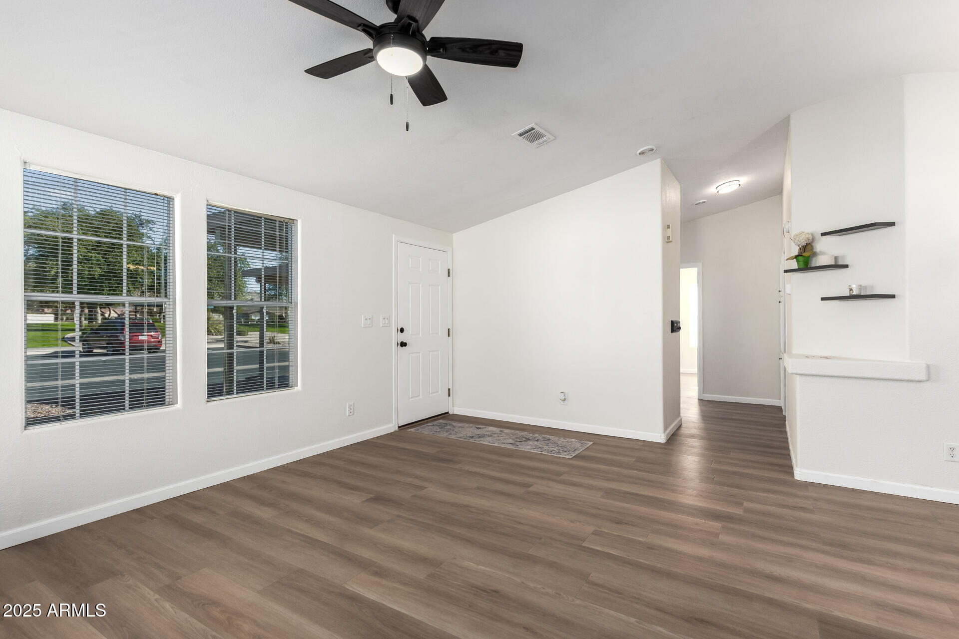 3301 South Goldfield Road, Unit 2006 Apache Junction, AZ 85119 - Photo 11 of 40 a view of an empty room with a window and wooden floor