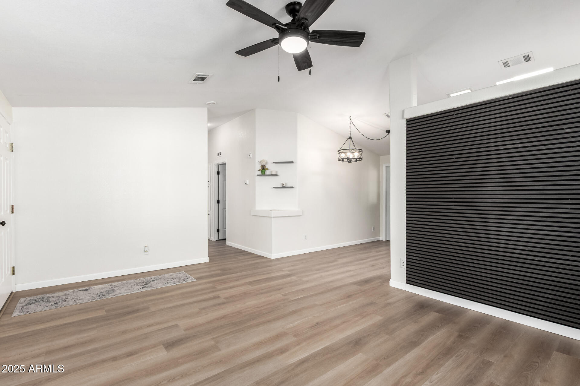 3301 South Goldfield Road, Unit 2006 Apache Junction, AZ 85119 - Photo 13 of 40 a view of an empty room with wooden floor and a ceiling fan