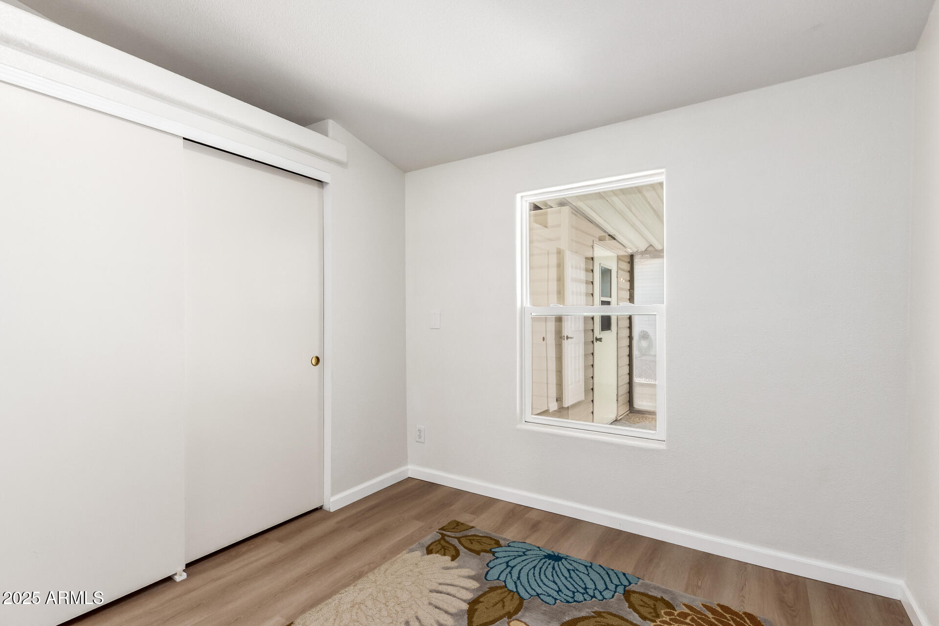 3301 South Goldfield Road, Unit 2006 Apache Junction, AZ 85119 - Photo 22 of 40 a view of an empty room with window and wooden floor