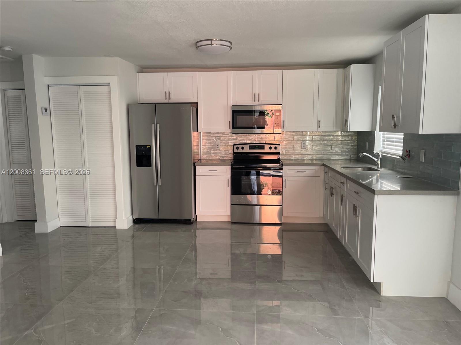 4281 Riverside Drive, Unit 3 Coral Springs, FL 33065 - Photo 3 of 8 a kitchen with stainless steel appliances granite countertop a refrigerator and a stove top oven