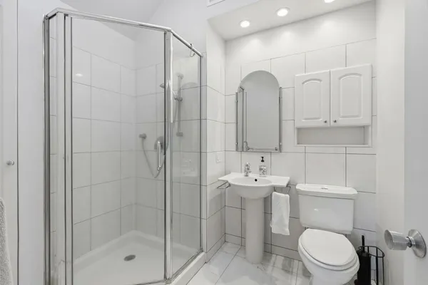 a bathroom with a sink a toilet and shower