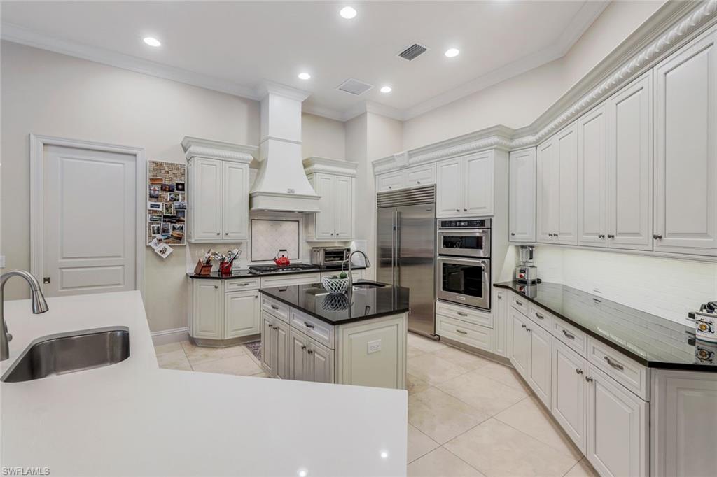 9243 Marble Stone Drive Naples, FL 34120 - Photo 11 of 50 a kitchen with stainless steel appliances a sink a stove a refrigerator and cabinets