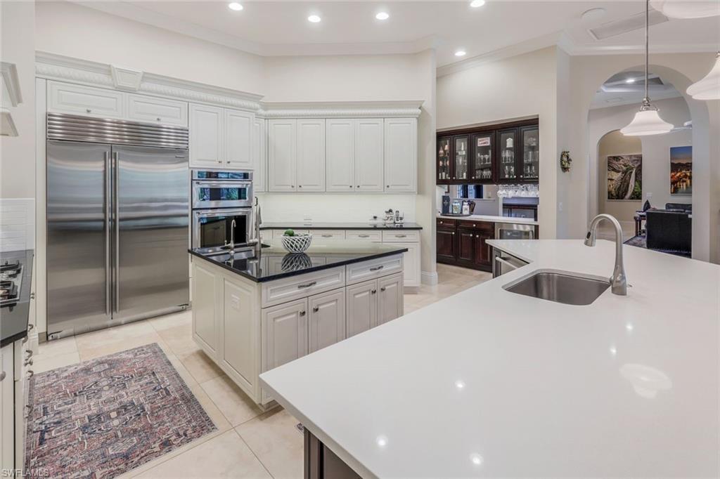 9243 Marble Stone Drive Naples, FL 34120 - Photo 13 of 50 a kitchen with stainless steel appliances a refrigerator a sink a stove top oven a counter space and cabinets