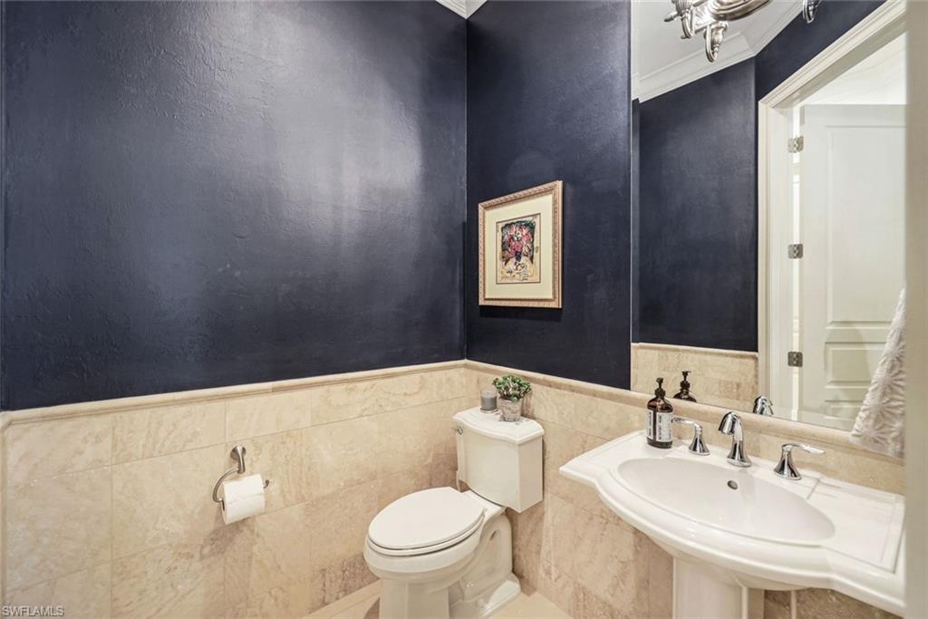 9243 Marble Stone Drive Naples, FL 34120 - Photo 32 of 50 a bathroom with a sink mirror vanity and toilet