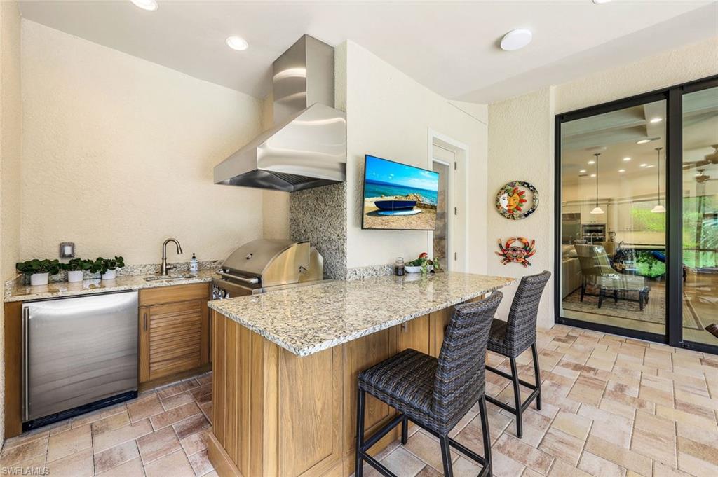 9243 Marble Stone Drive Naples, FL 34120 - Photo 40 of 50 a kitchen with a table chairs and a stove