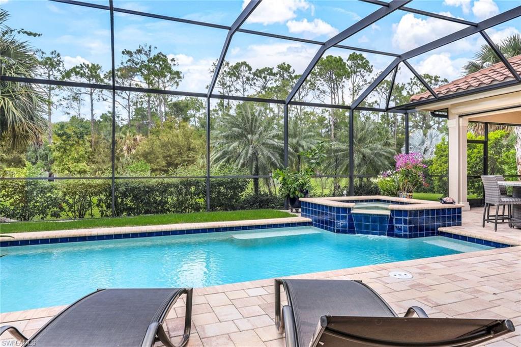 9243 Marble Stone Drive Naples, FL 34120 - Photo 45 of 50 a view of a swimming pool with a lounge chairs