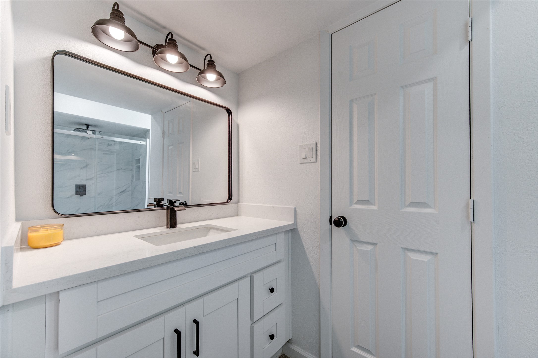 5411 Logston Lane Spring, TX 77389 - Photo 35 of 50 Sleek bathroom with a modern vanity, ample storage, and stylish lighting above a large mirror.