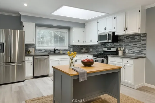 a kitchen with white cabinets and stainless steel appliances
