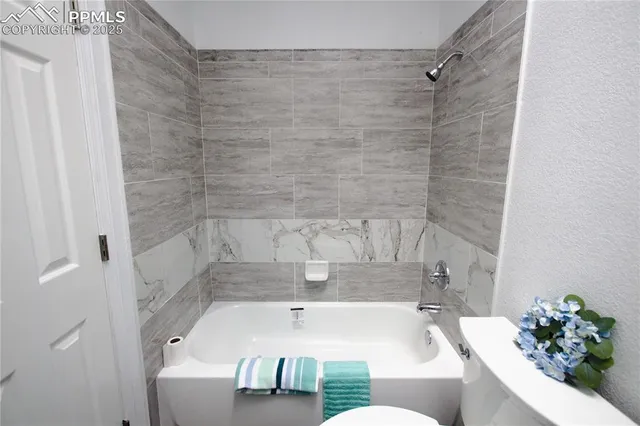 a bath tub sitting next to a white sink and a shower