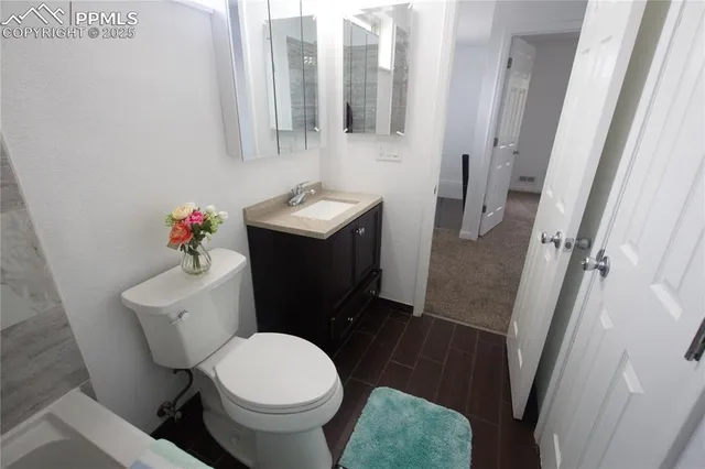 a white toilet sitting next to a bathroom sink and a mirror