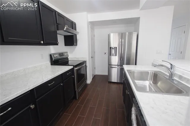 a kitchen with stainless steel appliances wooden cabinets a stove a sink and a refrigerator