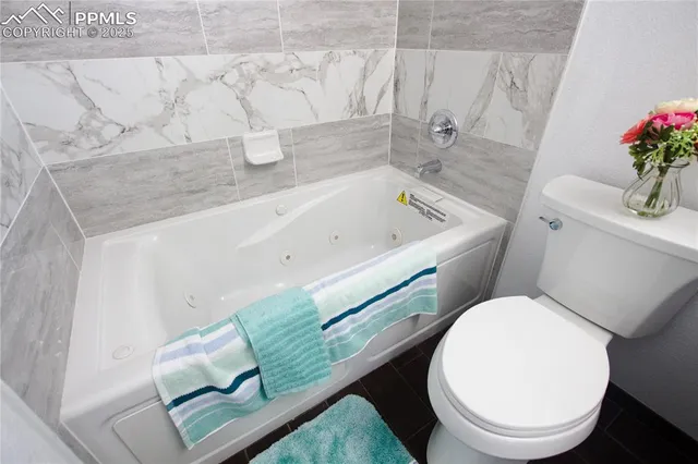 a white toilet sitting next to a bath tub