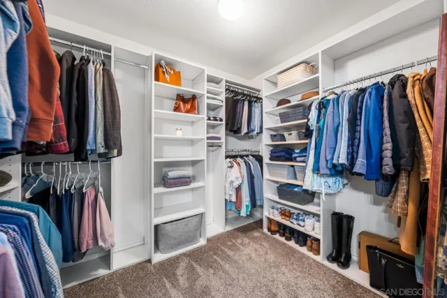 a view of walk in closet with clothes and shoes