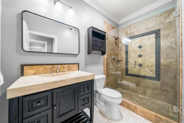 a bathroom with a granite countertop sink toilet a mirror and shower