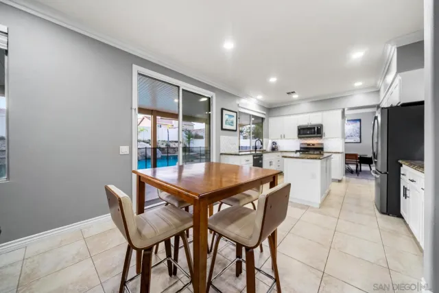 a dining hall with stainless steel appliances a dining table and chairs