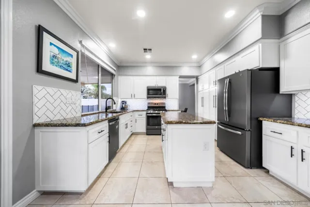 a kitchen with stainless steel appliances granite countertop a refrigerator oven a sink dishwasher and a refrigerator with wooden cabinets