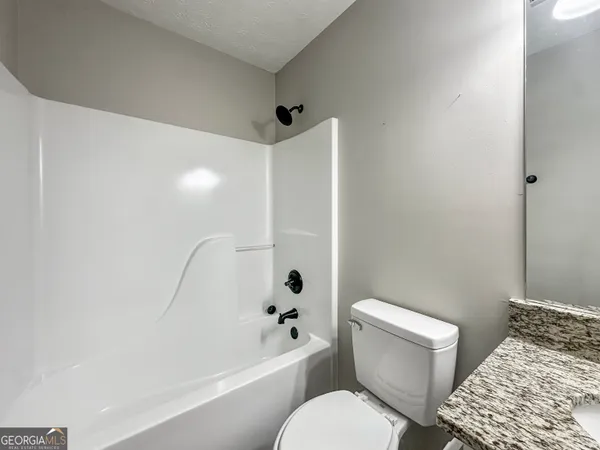 a white toilet sitting next to a bath tub