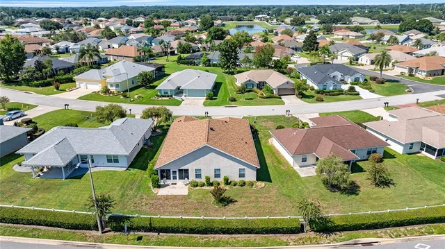 an aerial view of residential houses with outdoor space and parking