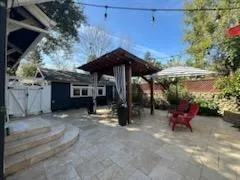 a view of a patio with a table and chairs under an umbrella