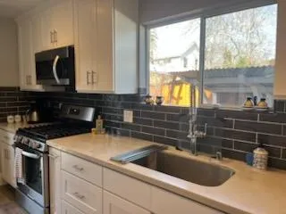 a kitchen with a sink a stove and cabinets