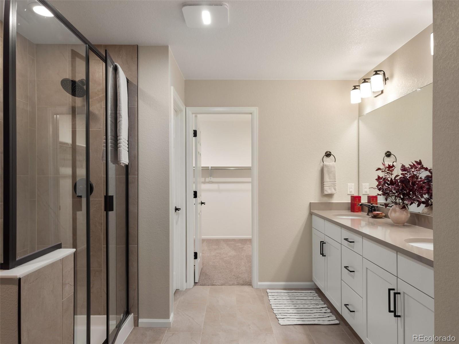 3957 Breakcamp Court Castle Rock, CO 80108 - Photo 24 of 50 a bathroom with a double vanity sink mirror and shower