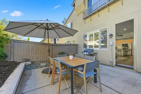 a patio with a table and chairs under an umbrella