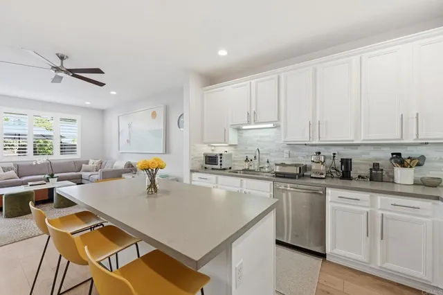 a kitchen with stainless steel appliances granite countertop a sink a stove a refrigerator a center island and a window